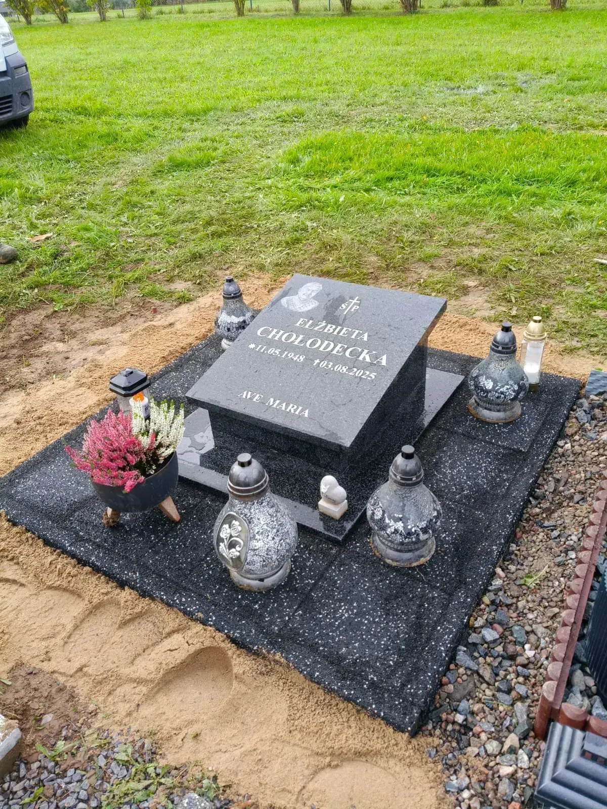 Nagrobek podwójny z czarnego granitu na jasnej podstawie