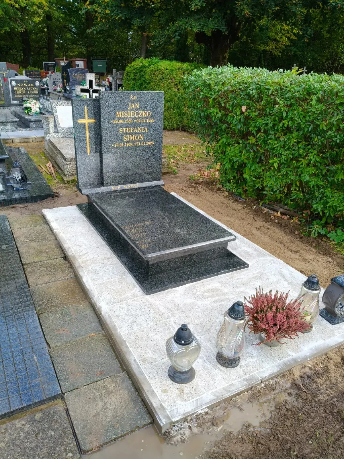 Nagrobek podwójny z czarnego granitu ze złotym krzyżem